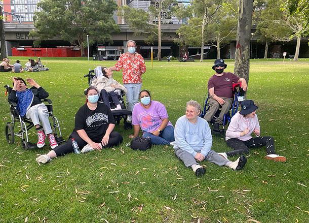 A group of people relax on the grass in a city park