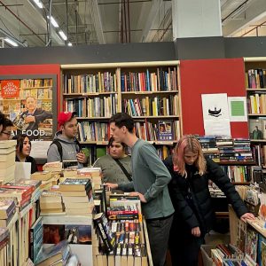 Five people look at book displays in a bookshop