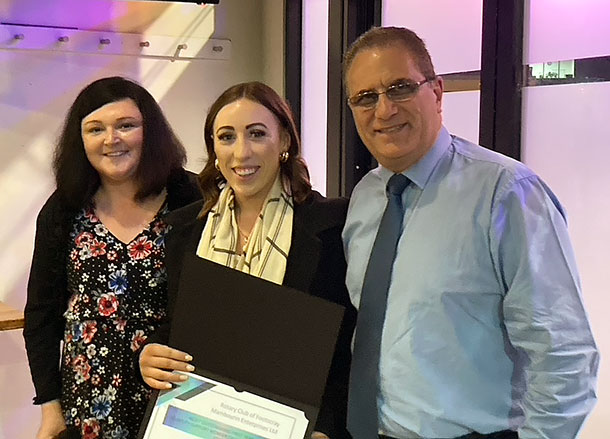 Cassandra, Courtney and Emanuel stand in a row smiling, Courtney is holding her certificate