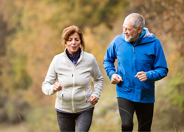 A man and a woman are in excercise gear and walking together outside