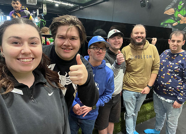 six people standing in a row smiling