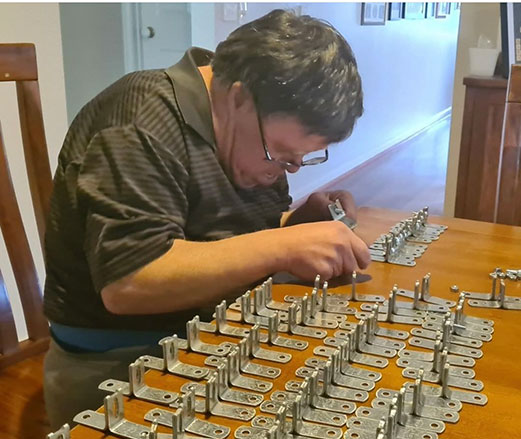 Garry is completing assembly work at a table