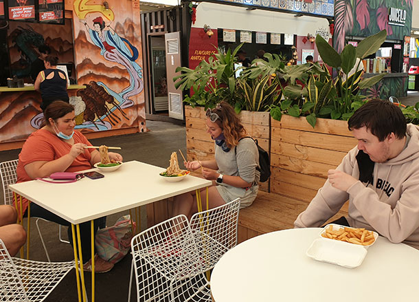 Keyannah, Brooke and Hamish are sitting in the Grazeland food court with plates of food in front of them