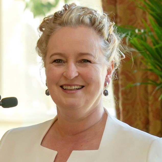 A portrait of Jo Swift, she is smiling and wearing a cream jacket