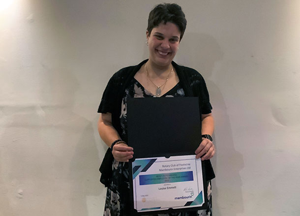 Louise smiling and holding a certificate