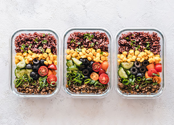 Three glass rectangular lunch boxes with healthy-looking food inside them