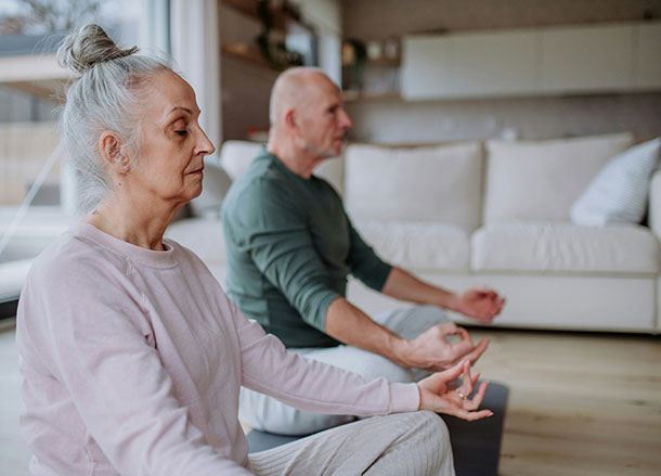 Woman and man sit on the floor meditating