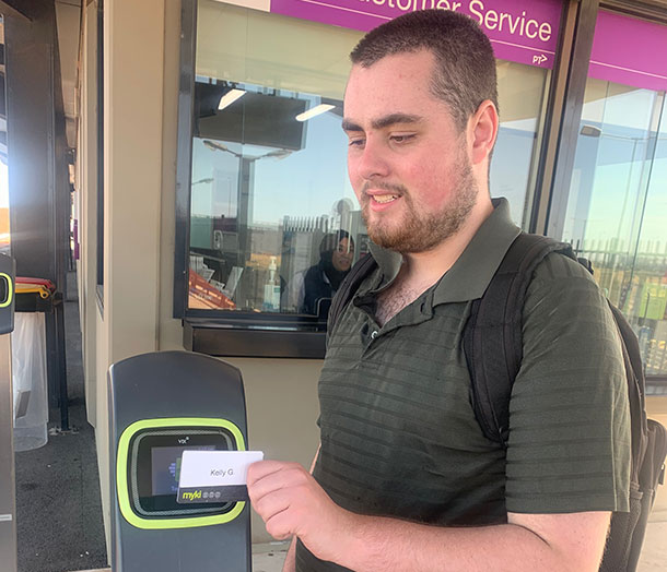A man taps his myki card on a card reader