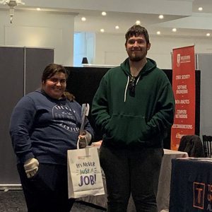 Nathan and keyannah are standing at an expo, they are smiling