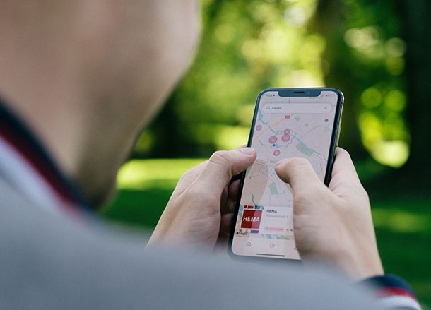 A person holds a mobile phone displaying a map