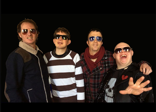 The four members of Rudely Interrupted all wearing sunglasses and standing against a black background