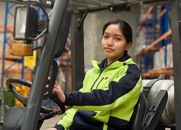 A young woman is driving a forklift