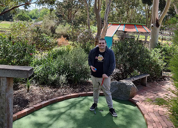 Thomas stands on a putting green with a golf club in his hand